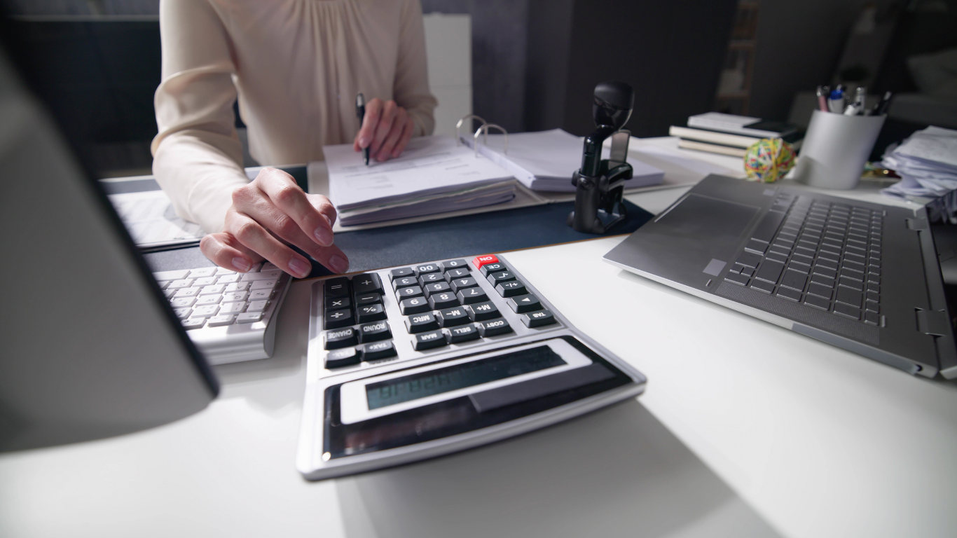 Accountant working at a desk reviewing financial data and reports